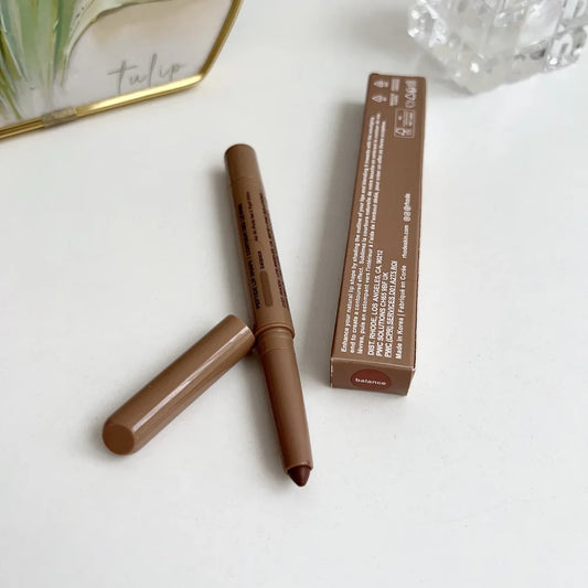 Brown makeup pencil with packaging on a white surface