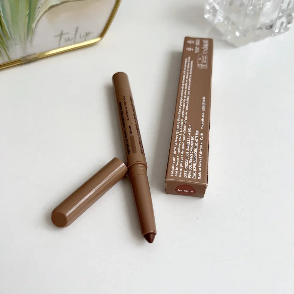 Brown makeup pencil with packaging on a white surface