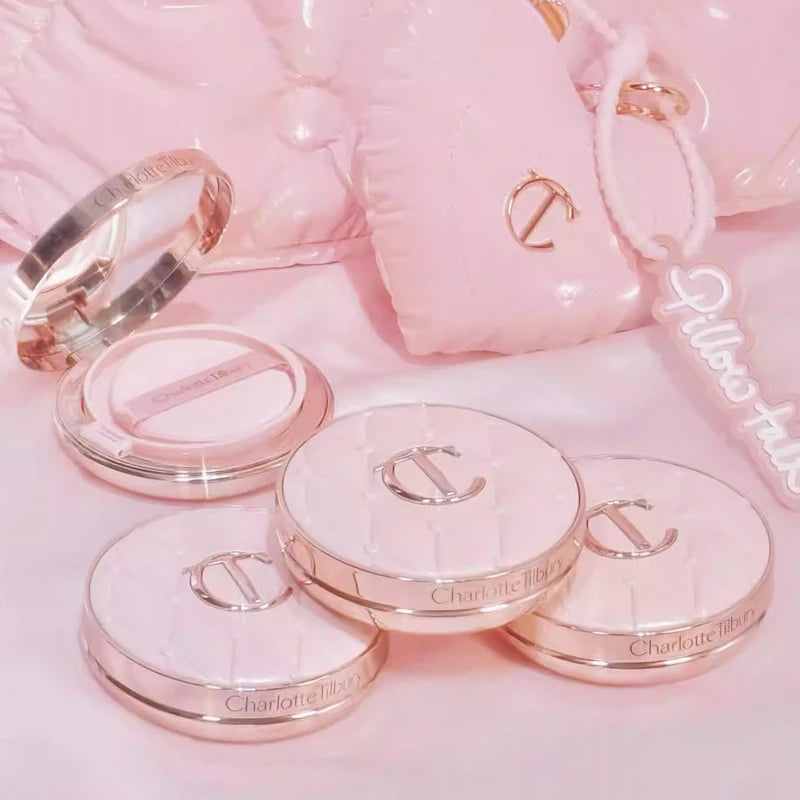 Makeup products with 'Charlotte Tilbury' branding on a pink background