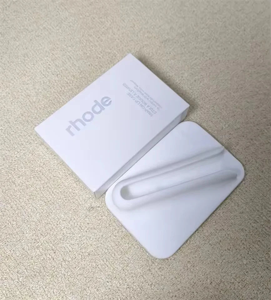 White phone case with 'rhode' branding on a beige surface