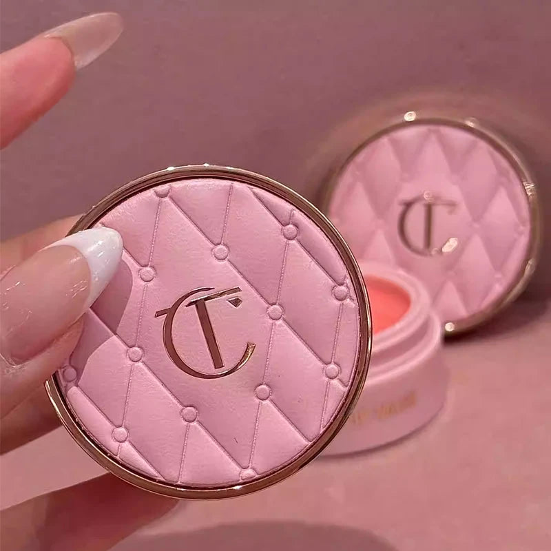 Pink makeup compact with a brand logo on a pink background