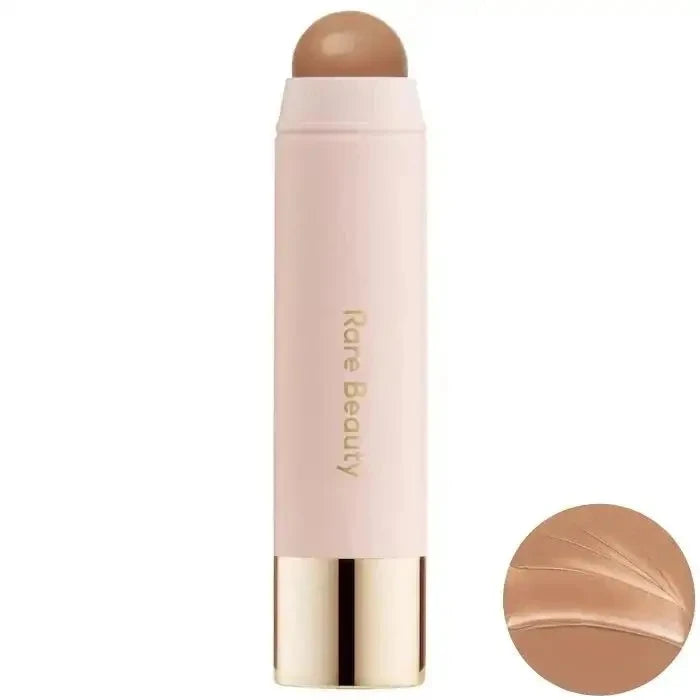 Makeup stick with a beige shade on a white background, featuring the brand 'Rare Beauty'.