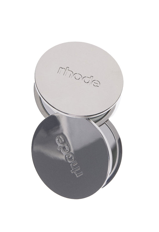 Silver round container with 'rhode' branding on a white background