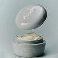 Rhode Caffeine Reset Recharge Caffeine Scraping Cream Mask in a matte gray jar with the lid floating above, showing the cream inside, on a matching gray background.