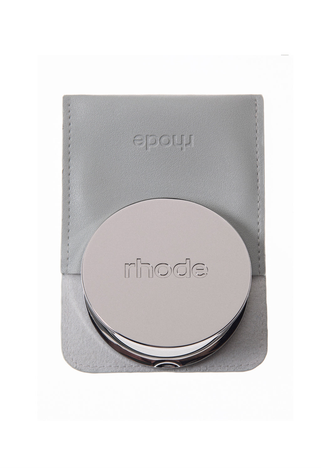Round metallic object with 'rhode' branding on a gray leather pouch against a white background