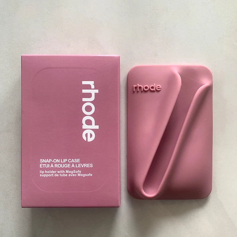 Pink lip case with 'rhode' branding next to its packaging on a light background