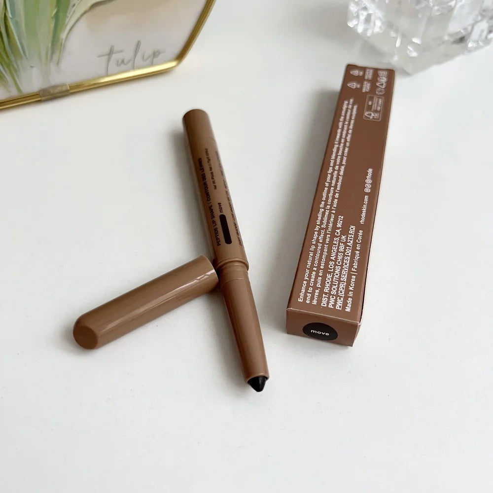 Brown makeup pencil with black cap and its packaging on a white surface.