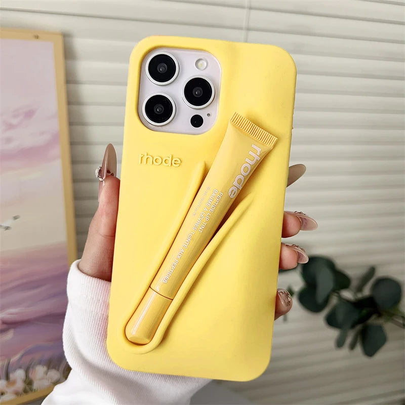 Yellow phone case with a lip gloss holder held by a hand against a neutral background