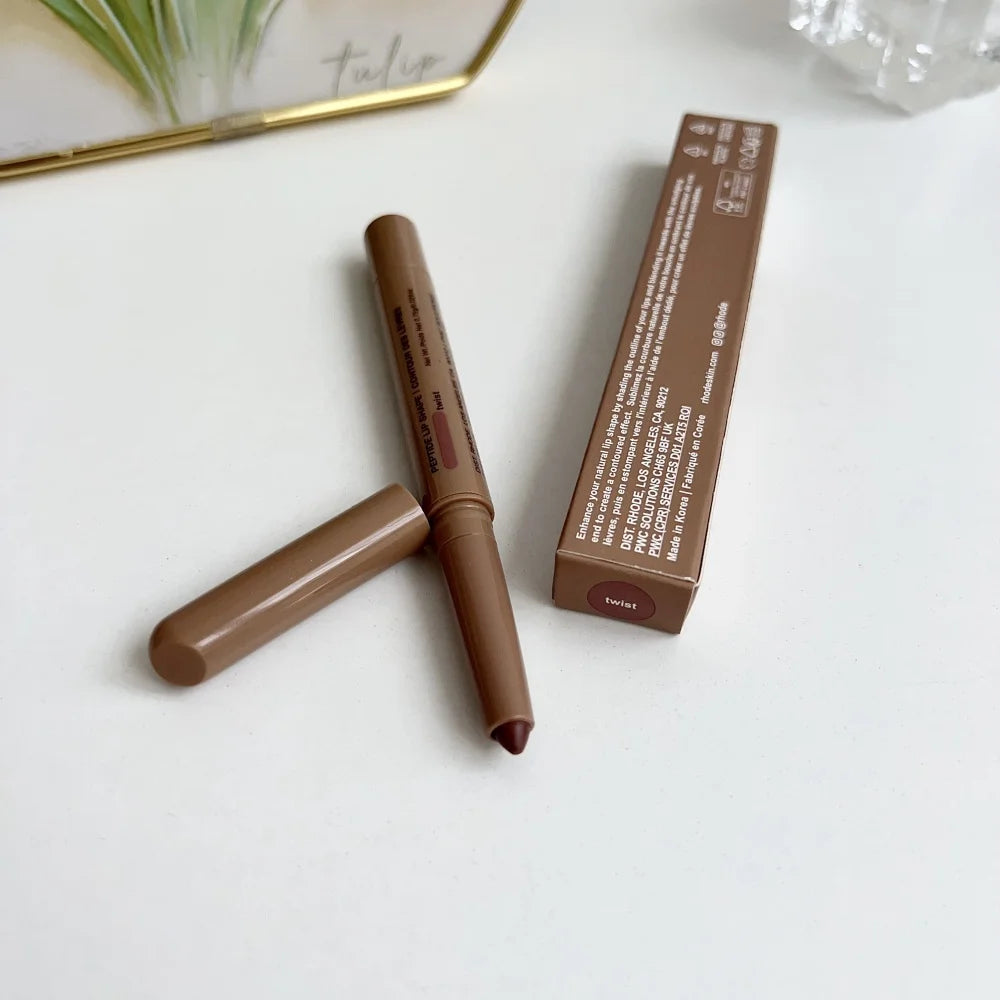 Brown makeup pencil with packaging on a white surface