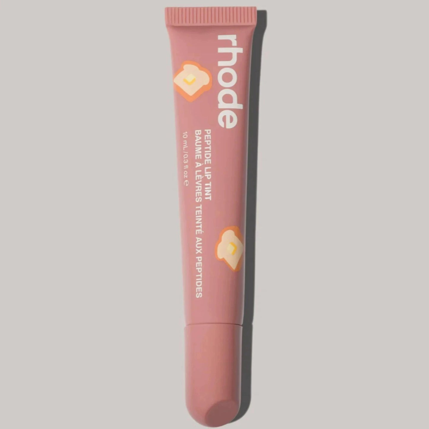 Pink lip balm tube with 'rhode' branding on a gray background