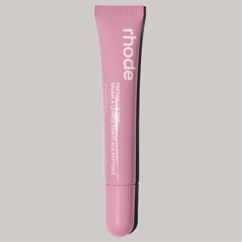 Pink cosmetic tube with 'rhode' branding on a light gray background