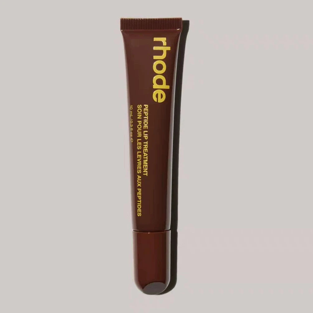 Brown lip treatment tube with 'rhode' branding on a gray background