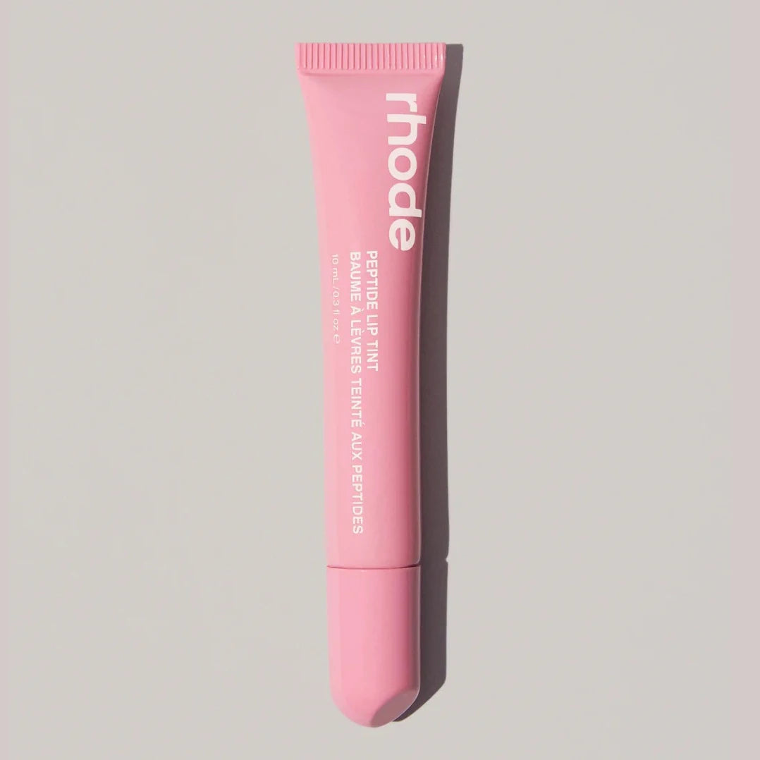 Pink lip balm tube with 'rhode' branding on a light gray background