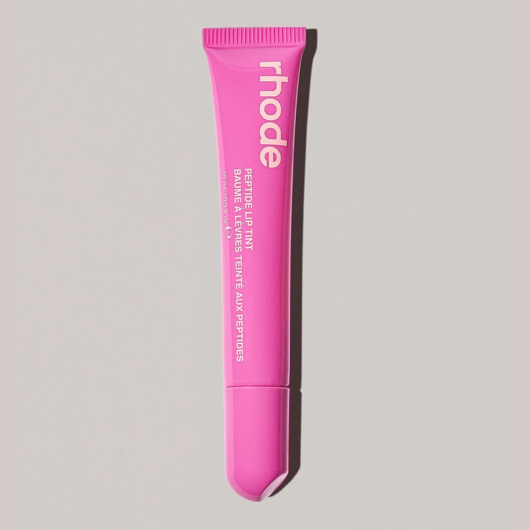 Pink lip treatment tube with 'rhode' branding on a gray background