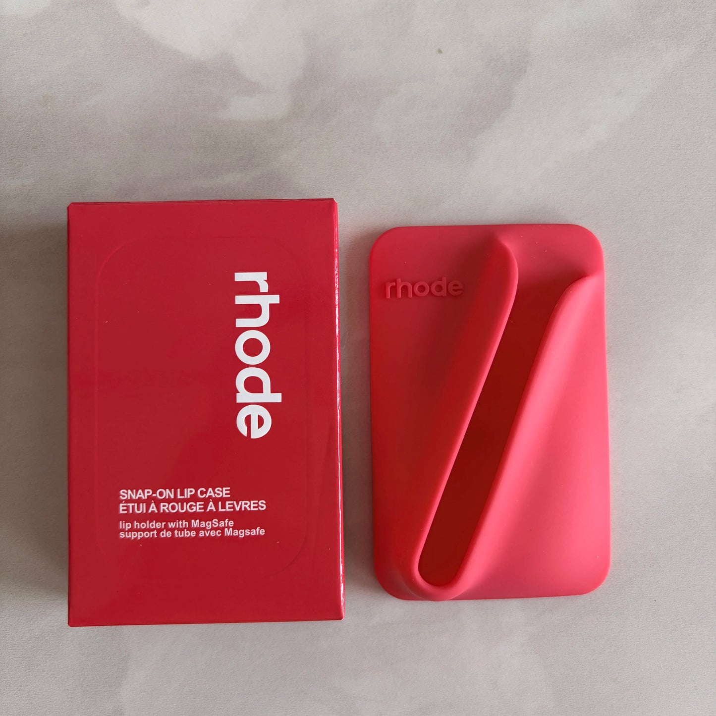 Red 'rhode' snap-on lip case on a light gray background