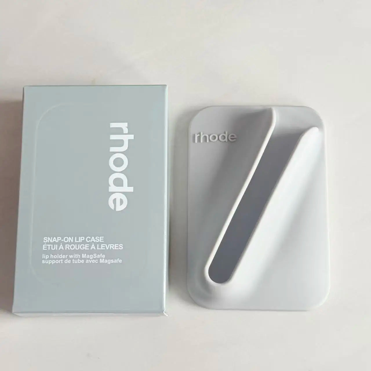 Gray lip case with 'rhode' branding on a light gray background