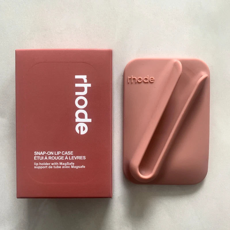 Pink lip case with 'rhode' branding next to its packaging on a light background